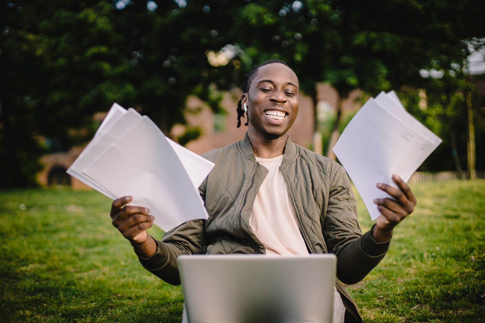A student celebrating admission results with papers in both hands